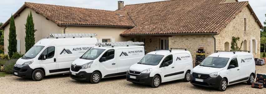Les fourgons logotés Altys Toiture Coutras alignés devant le local de l’entreprise